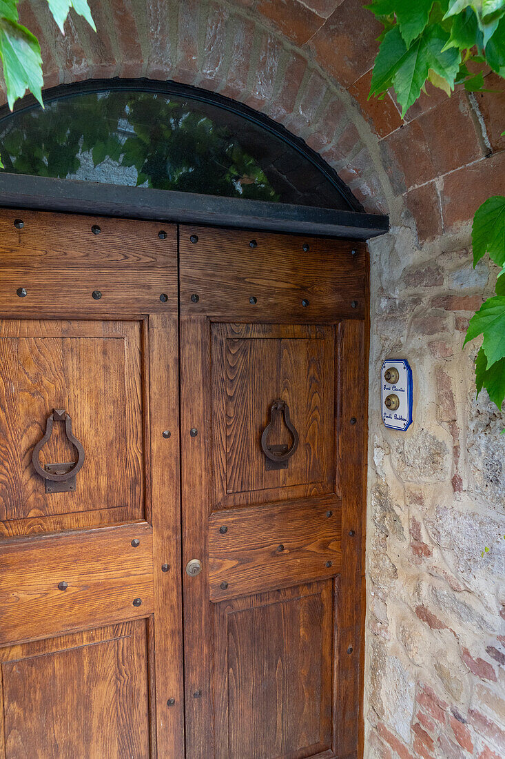 Hölzernes Portal eines Wohnhauses in der mittelalterlichen Stadt Monteriggioni,Siena,Toskana,Italien.