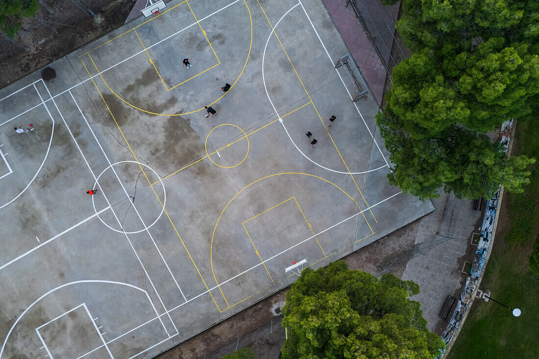 Basketball and soccer exterior courts among trees in city park, Zaragoza, Spain