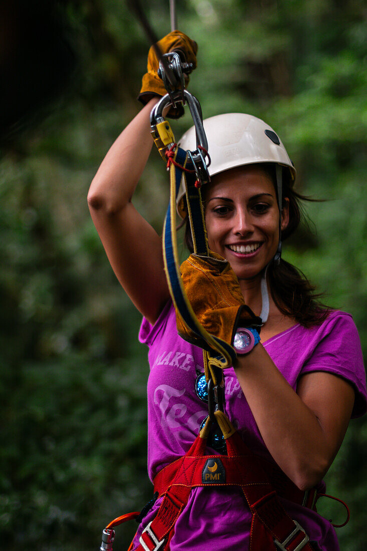 Young caucasian woman having fun during a Canopy tour in Costa Rica