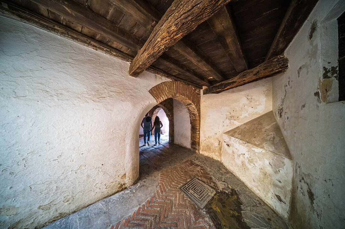 Ancient archway in Santa Cruz Quarter, Sevilla, showing historical architecture.