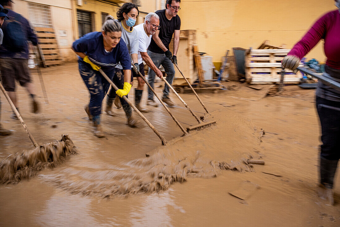 People cleaning. Effects of the DANA floods of October 29, 2024, Pelayo street, Paiporta, Comunidad de Valencia, Spain