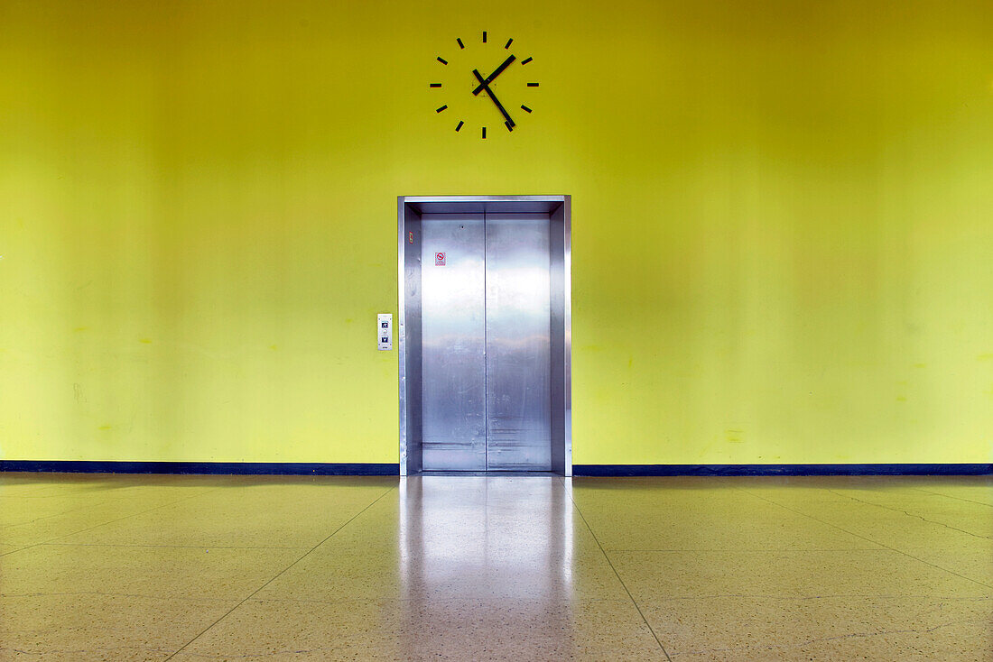 Berlin, Germany, July 29 2009, A sleek elevator entrance is set against a vibrant yellow wall inside the House of World Cultures in Berlin.