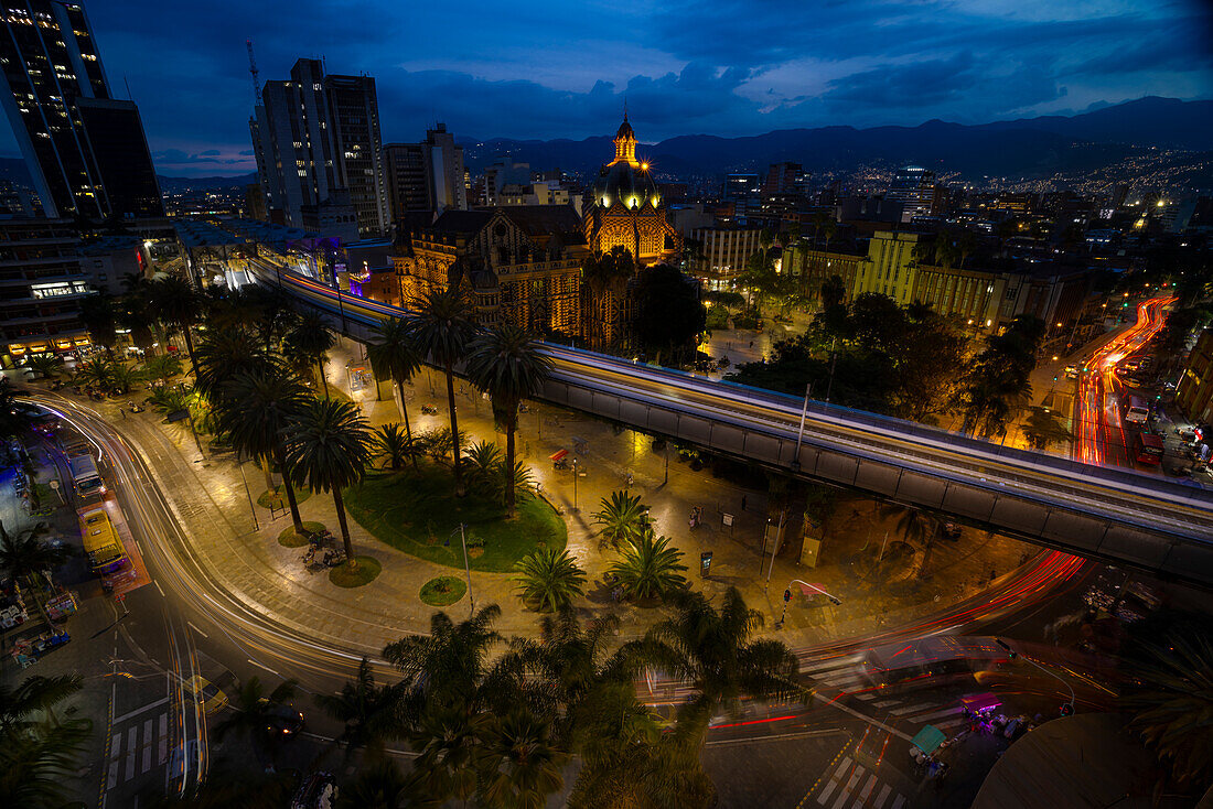 Blick auf die Plaza Botero und das berühmte Metrosystem bei Nacht,Medellin,Kolumbien. Die Metro umfasst Züge auf Straßenebene und sogar Seilbahnen,die das Stadtzentrum mit den ärmeren Vierteln in den umliegenden Bergen verbinden.