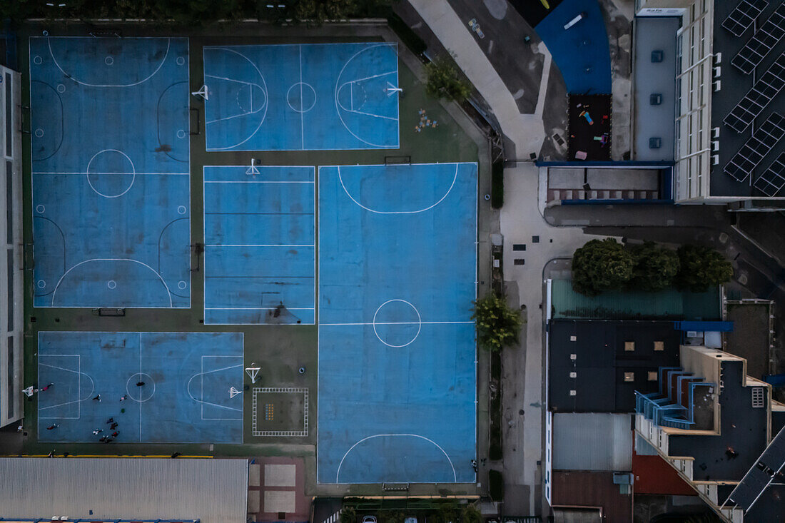 Aerial view of blue basketball and sports courts in school playground