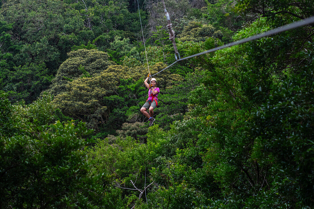 Young caucasian woman having fun during a Canopy tour in Costa Rica