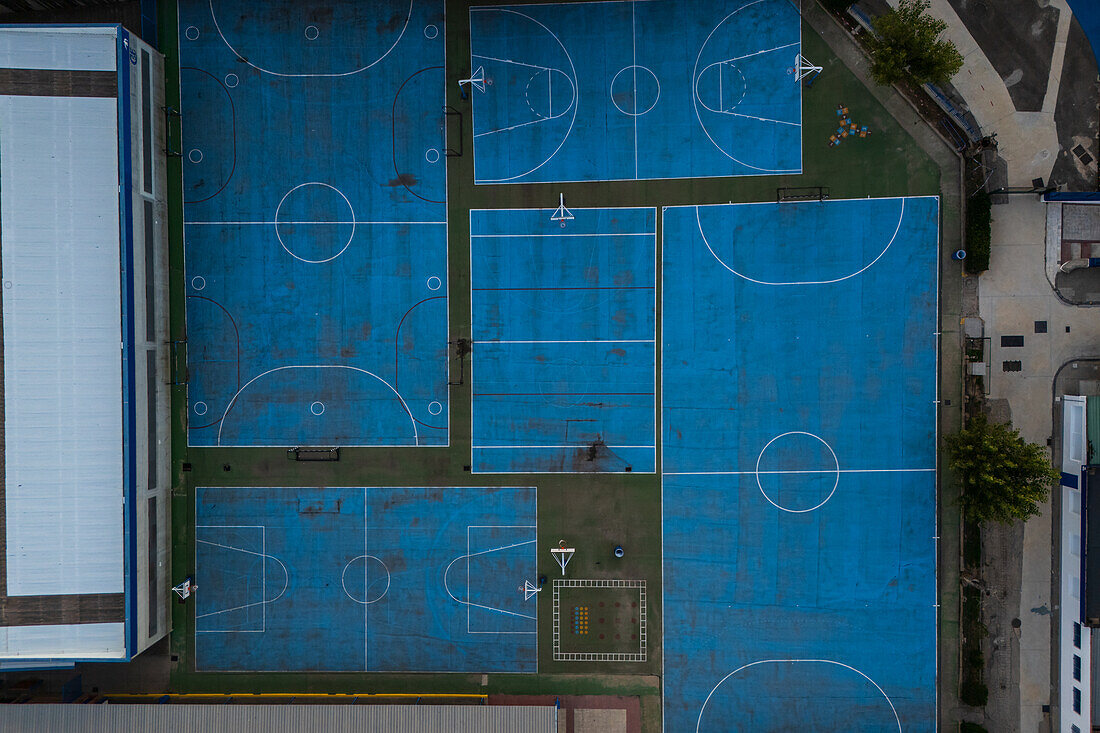 Aerial view of blue basketball and sports courts in school playground