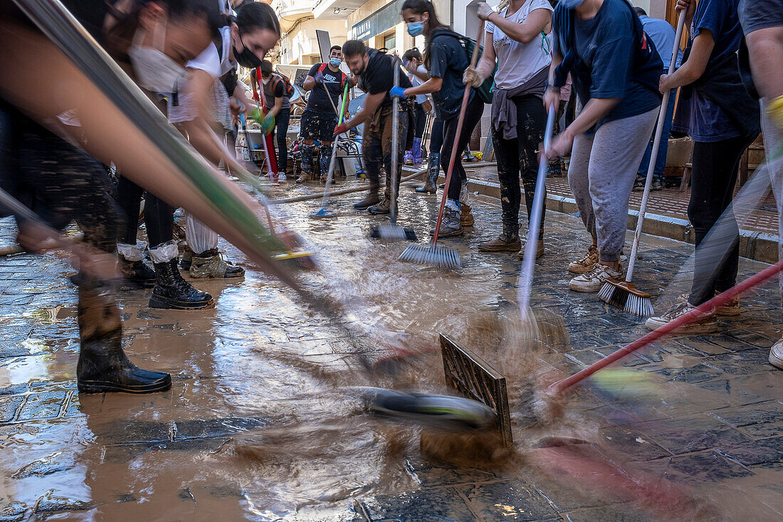 Menschen putzen. Auswirkungen der DANA-Überschwemmungen vom 29. Oktober 2024 in der Straße Benetusser,Paiporta,Comunidad de Valencia,Spanien