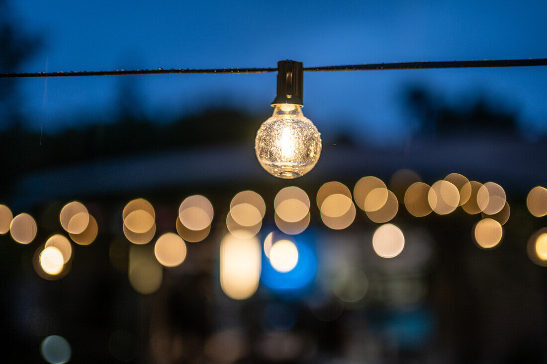 A close up of enchanting string lights at an outdoor wedding celebration in Malaga, Spain, creating a romantic and festive ambiance.