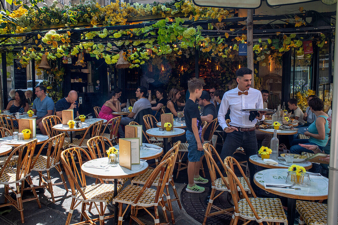 Menschen sitzen im Café-Restaurant Carrousel de Rennes in einer Allee in Montparnasse Paris Frankreich EU Europa