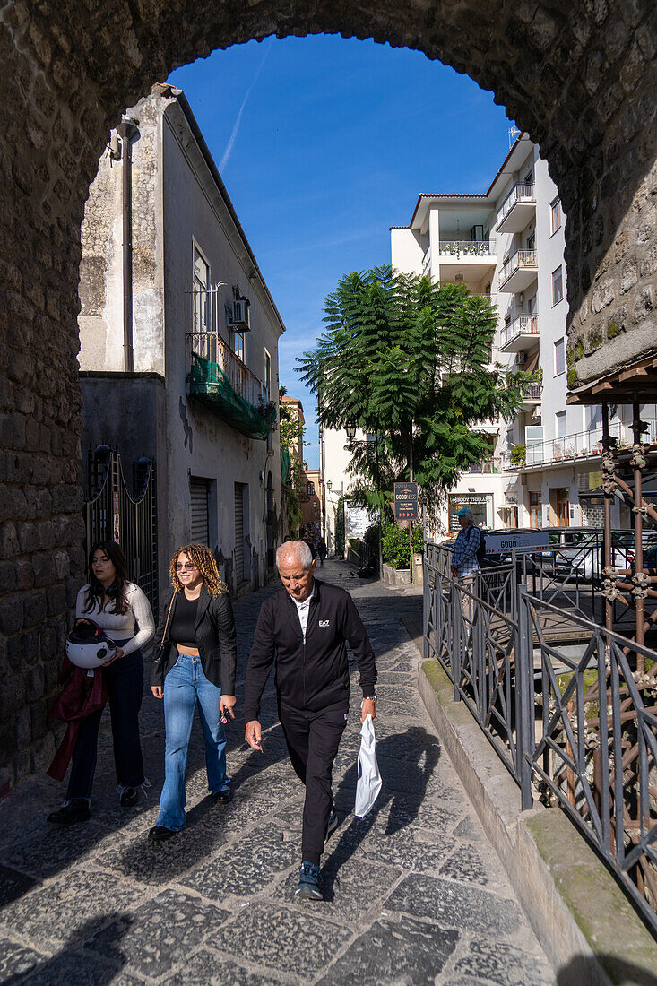 People passing through the historic city gate on the Via Antonino Sersale in Sorrento, Italy.