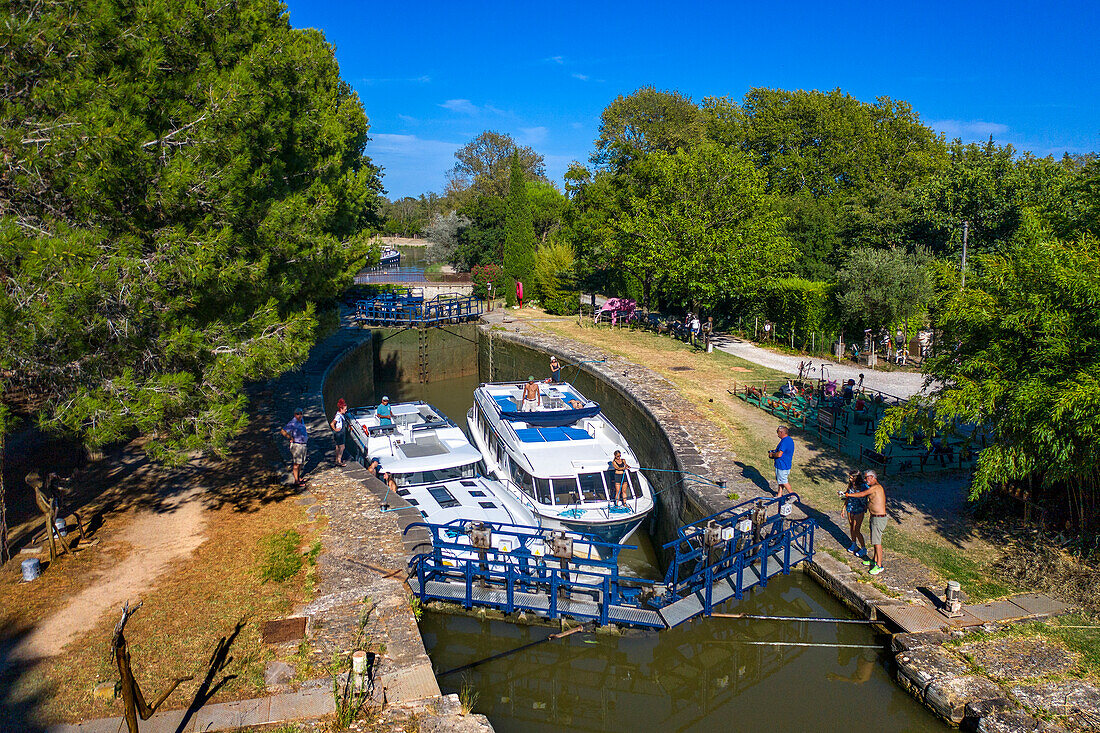 Blick aus der Luft auf die Écluse de l'aiguille Puichéric. Canal du Midi bei dem Dorf Puichéric Carcassonne Aude Südfrankreich Südliche Wasserstraße Wasserstraßen Urlauber stehen Schlange für eine Bootsfahrt auf dem Fluss, Frankreich, Europa