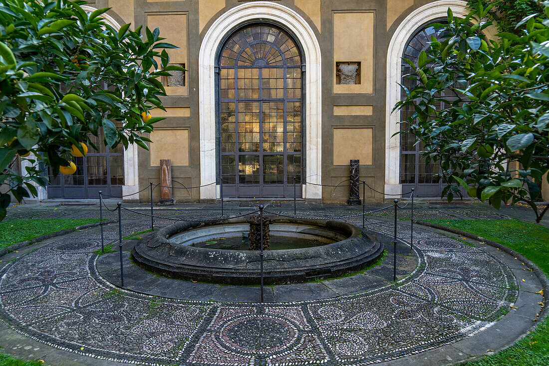 Mosaic designs in the walkway around a fountain in the gardens of the Palazzo Medici Riccardi. Florence, Italy.