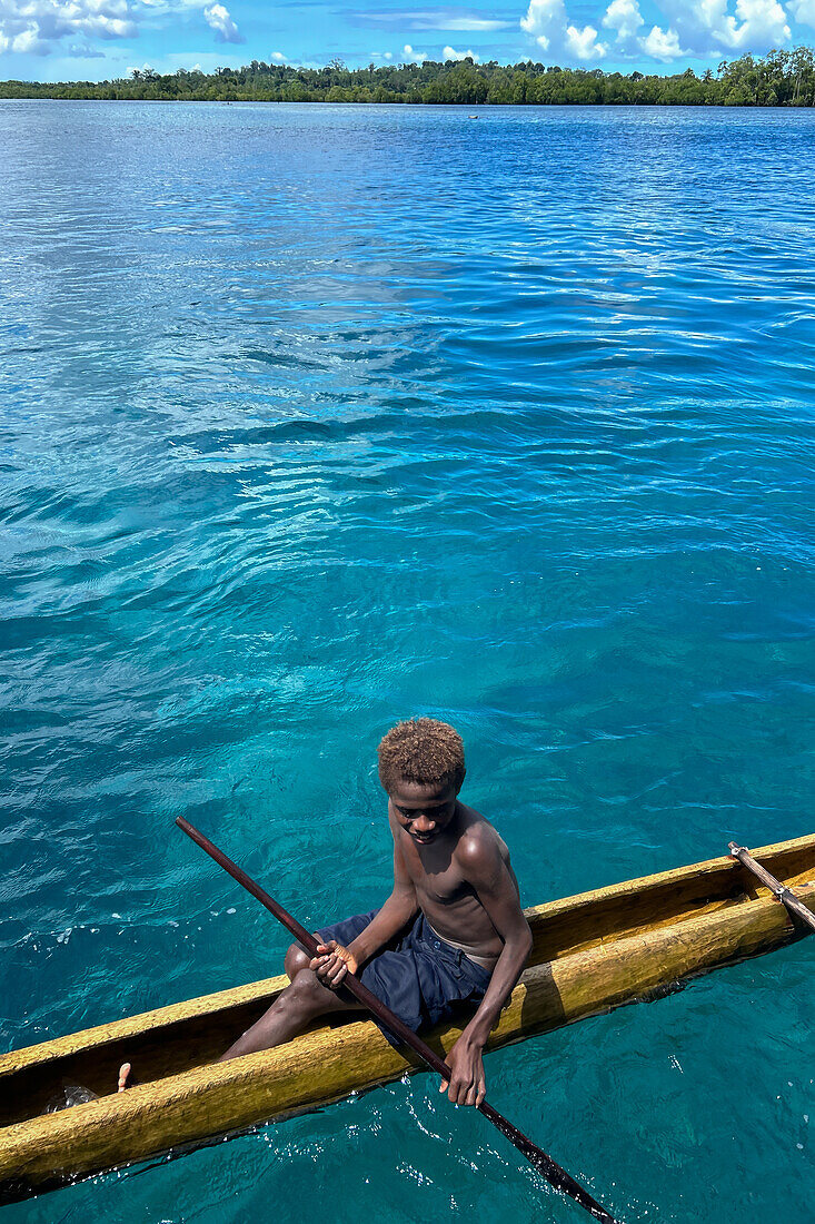 Residents of Tungelo Island in their traditional dugout canoes, New Ireland province, Papua New Guinea