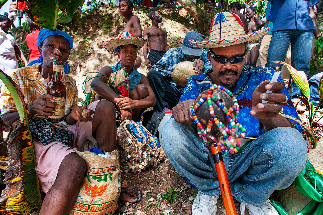 Haiti Voodoo Festival in Saut d'Eau, in Saut d'Eau, Ville Bonheur, Haiti. Tausende von Vodou- und katholischen Anhängern versammelten sich unter dem Wasserfall von Saut d'Eau in Haiti. Die Wallfahrt, die sowohl von Voodou-Anhängern als auch von Katholiken unternommen wird, hat ihren Ursprung in der Sichtung des Bildes der Jungfrau Maria auf einem Palmblatt in der Nähe des Wasserfalls vor einem halben Jahrhundert. Der Katholizismus und die Voodou-Praktiken sind in ihrer haitianischen Form für immer miteinander verwoben. Das Erscheinen eines Regenbogens unter den Wasserfällen soll bedeuten, dass