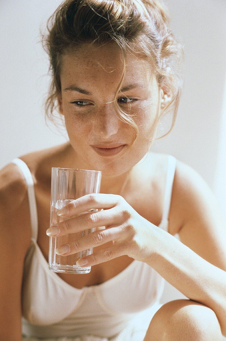 Young woman holding a glass of water