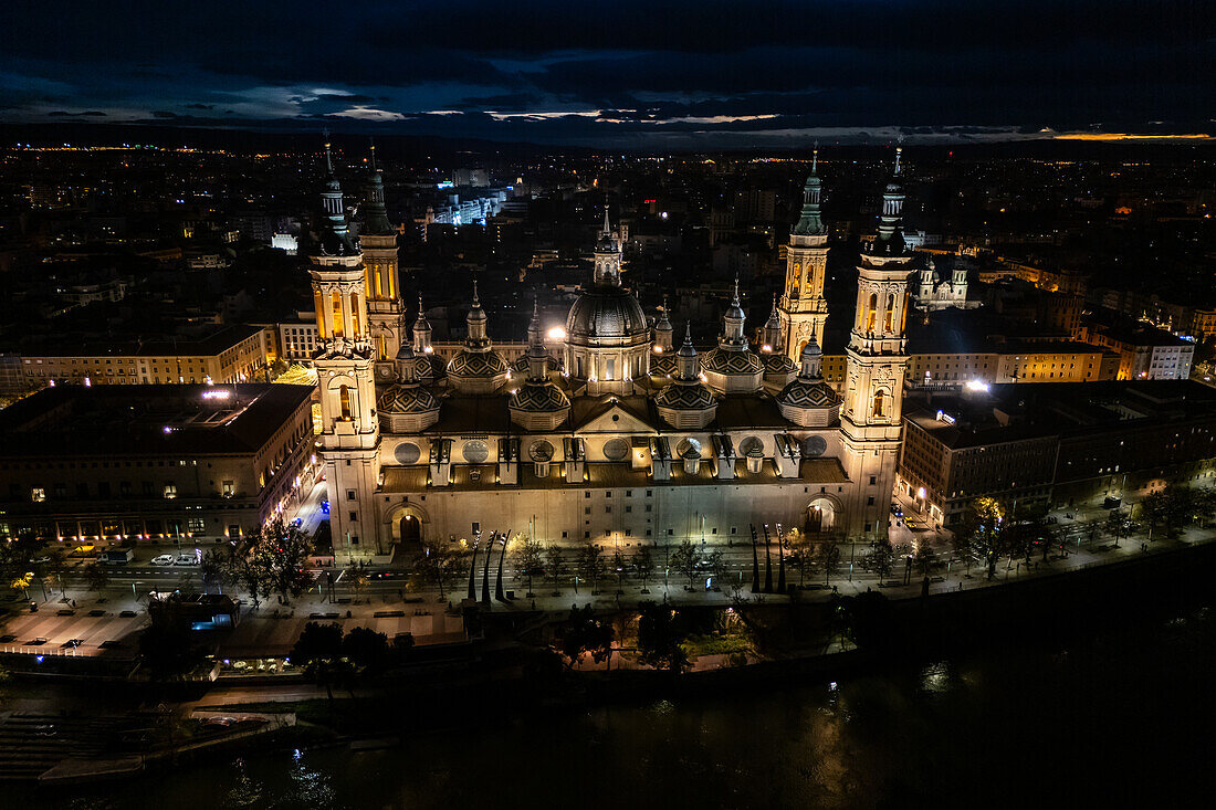 Luftaufnahme der nächtlich beleuchteten Kathedrale Unserer Lieben Frau von der Säule während der Weihnachtszeit in Zaragoza, Spanien