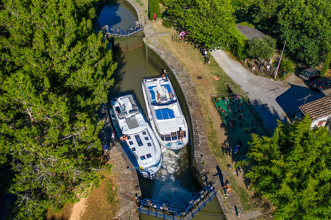 Blick aus der Luft auf die Écluse de l'aiguille Puichéric. Canal du Midi bei dem Dorf Puichéric Carcassonne Aude Südfrankreich Südliche Wasserstraße Wasserstraßen Urlauber stehen Schlange für eine Bootsfahrt auf dem Fluss, Frankreich, Europa