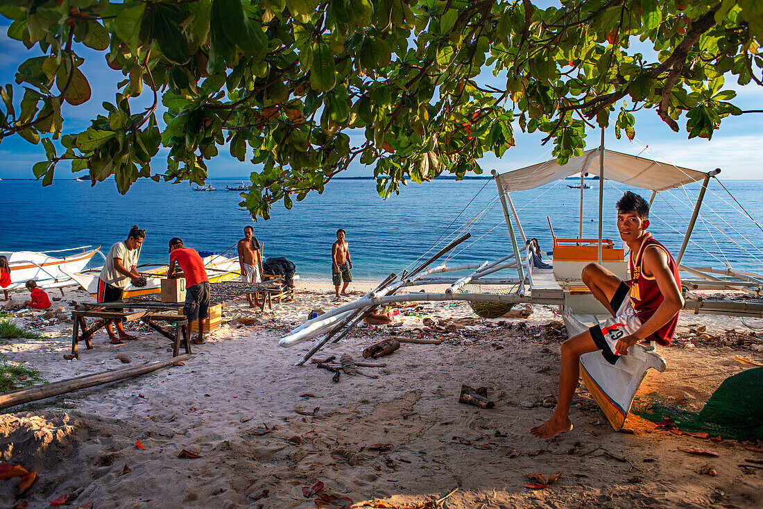 Einheimische Fischer am Guimbitayan-Strand neben dem weißen Sandstrand auf der Insel Malapascua, Cebu, Philippinen