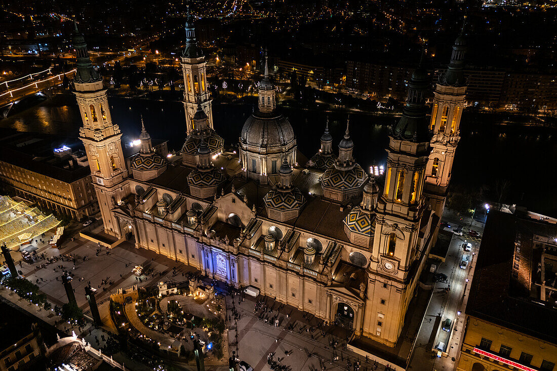 Aerial view of the Cathedral Basilica of of Our Lady of the Pillar and El Pilar square illuminated at night during Christmas, Zaragoza, Spain