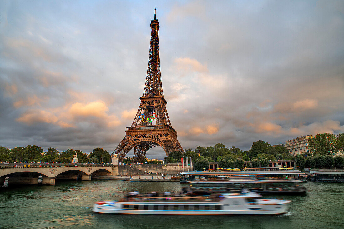 Scenic panorama of Eiffel Tower, Seine River, and pont d'lena in Paris, France; with a cruise passing by ferry