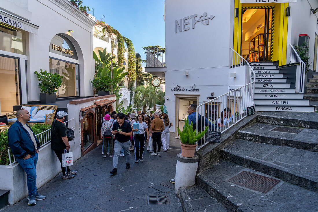 Touristen und Geschäfte auf einer Straße in der Stadt Capri, der größten Gemeinde der Insel Capri, Italien.