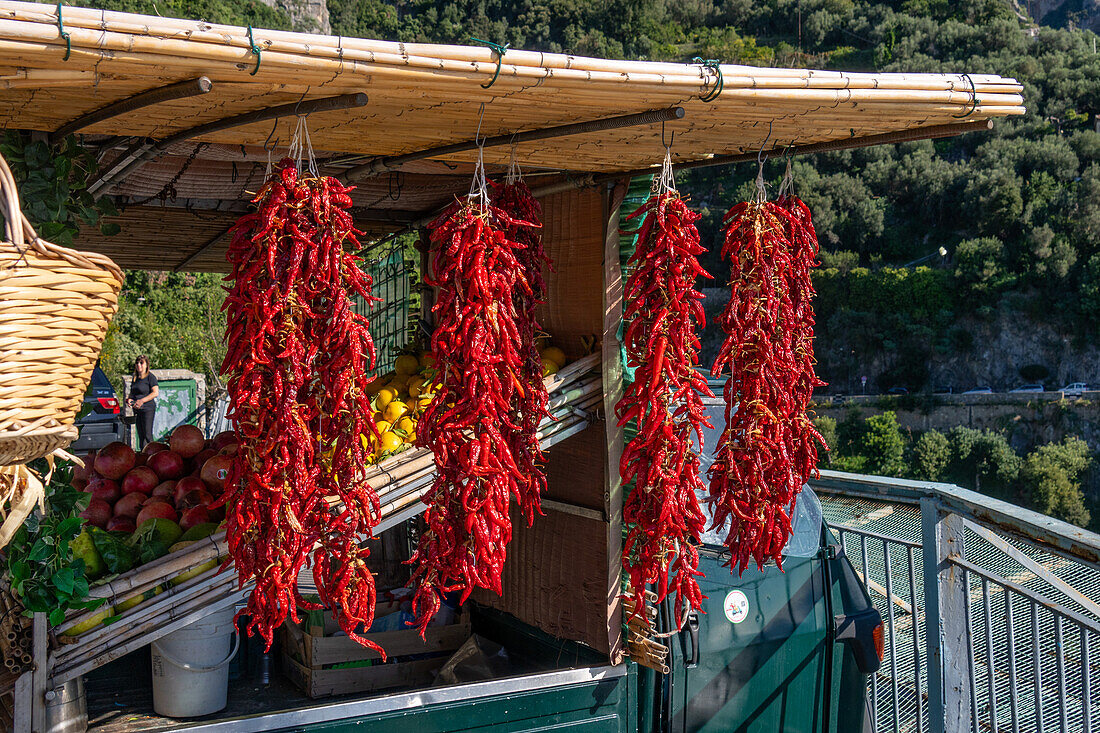 Strands of dried chili peppers for sale by a roadside vendor on the Amalfi Coast road in Italy.