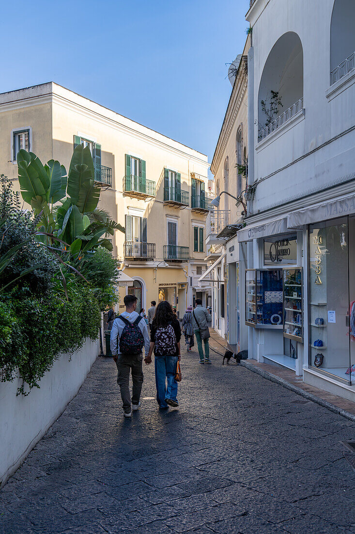 Touristen und Geschäfte auf einer Straße in der Stadt Capri, der größten Gemeinde der Insel Capri, Italien.