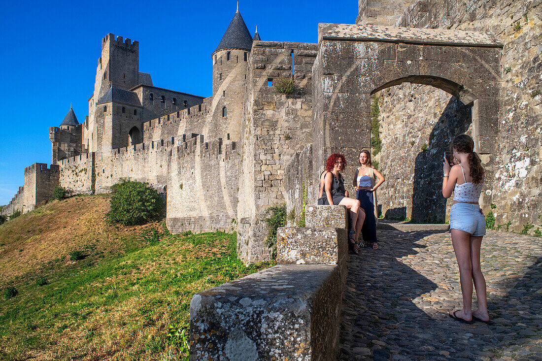 Touristen auf den Festungsmauern der mittelalterlichen Burg von Carcassonne in Frankreich, beliebte Touristenattraktion, Europa