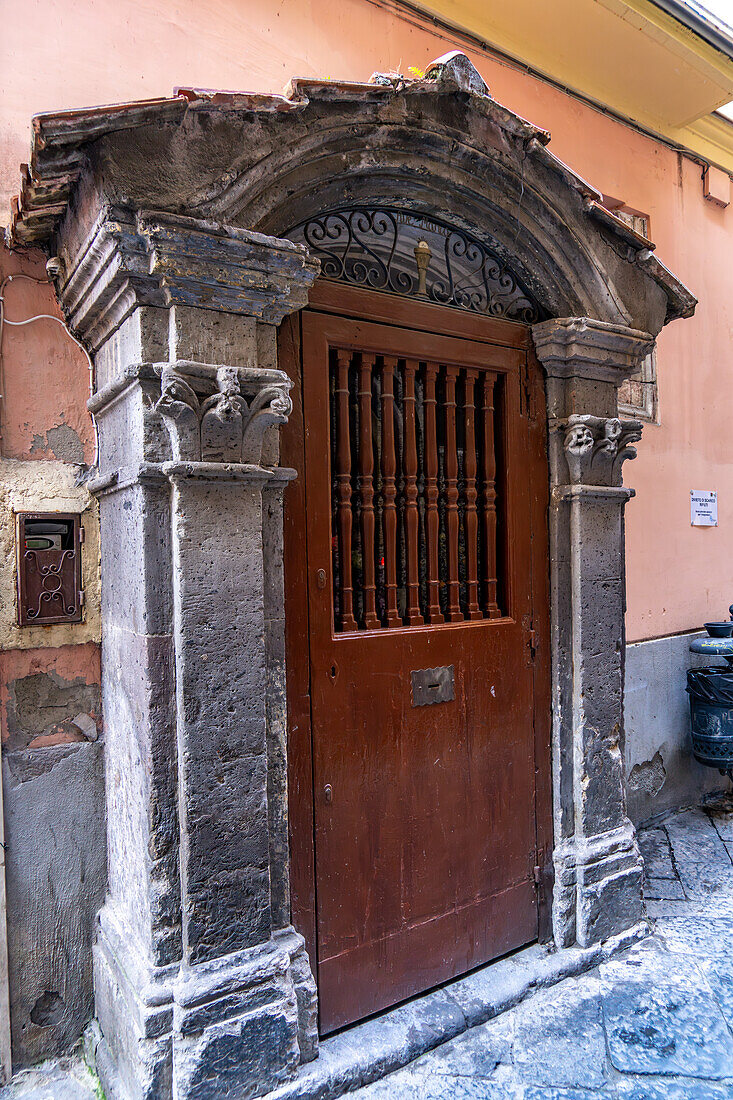 Ein sehr altes geschnitztes Steintor an einem Gebäude in der Via Santa Maria della Pieta in Sorrent, Italien.