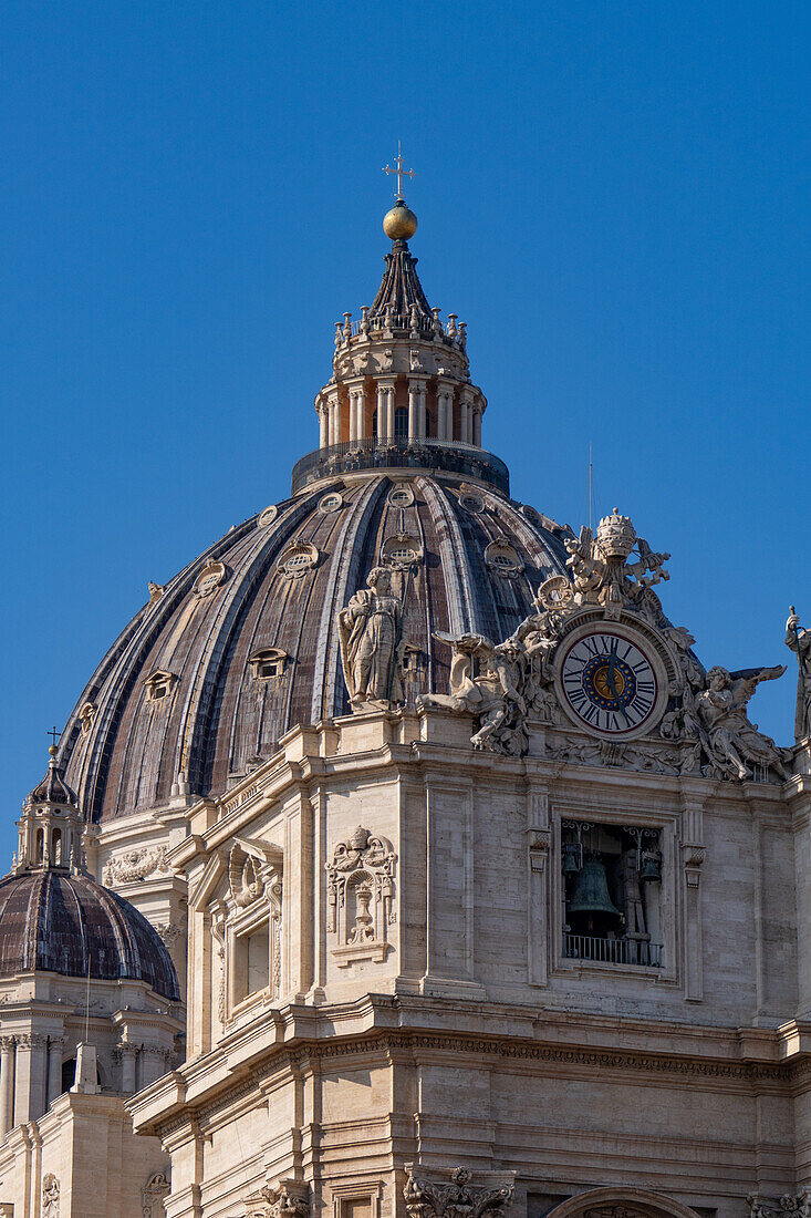 Die Kuppel und die Statuen auf dem Dach der Fassade des Petersdoms in der Vatikanstadt in Rom, Italien.