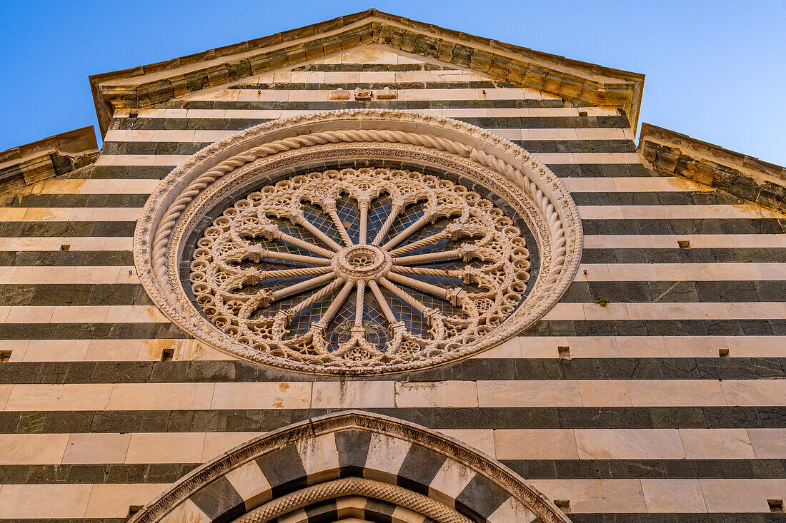 The rose window of the medieval Church of San Giovanni Battista in Monterosso al Mare, Cinque Terre, Italy. The facade is black and white marble.