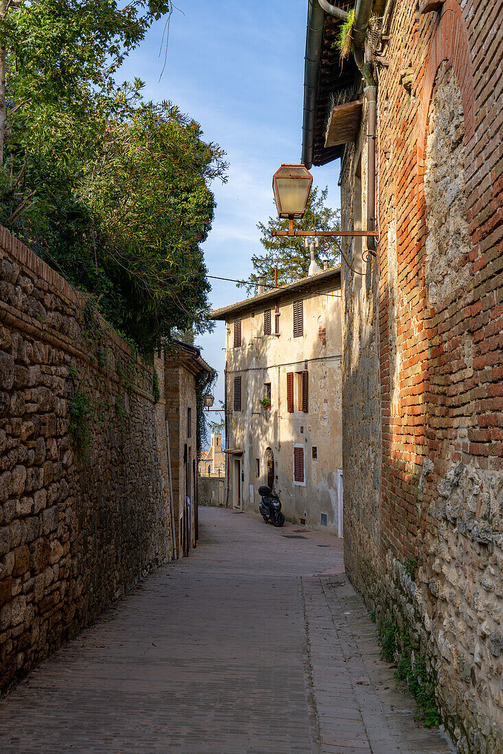 A motorscooter parked on a narrow side street in the medieval walled city of San Gimignano, Italy.