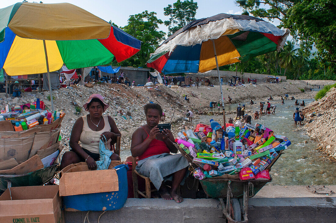 Müll und Straßenverkäufer am Ufer des Riviere de la Cosse, Jacmel, Haiti