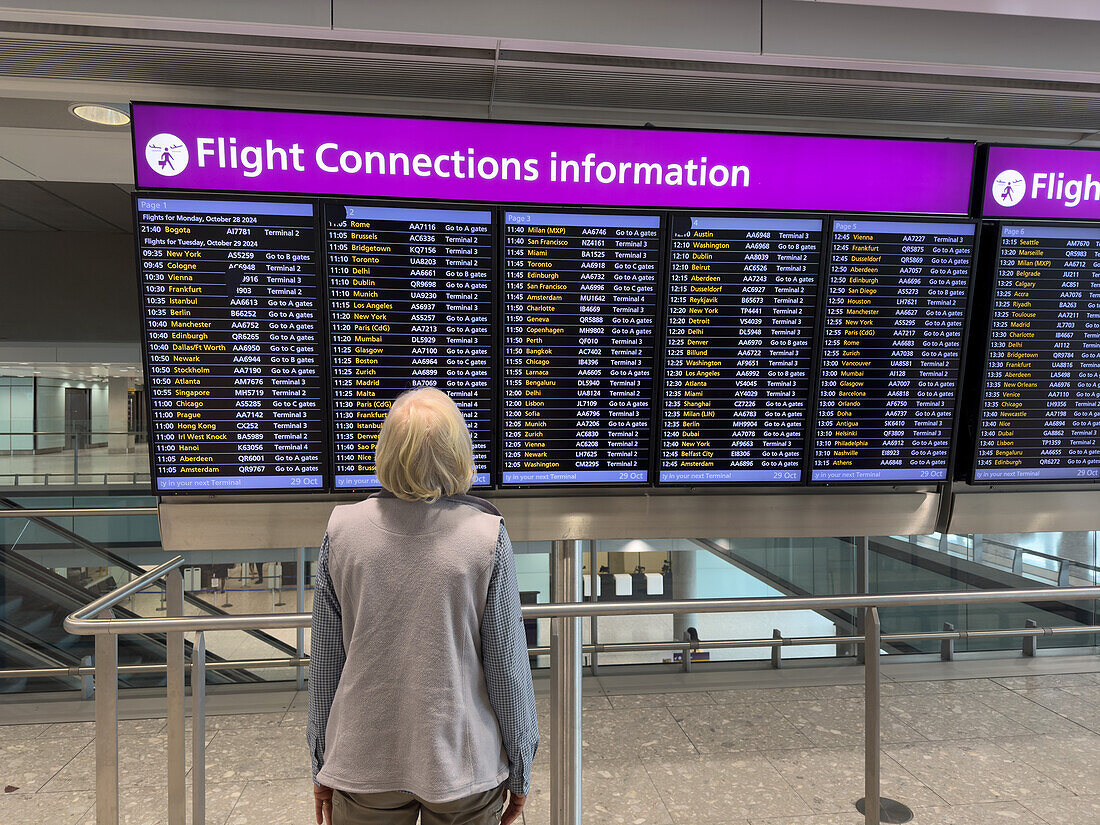 A traveler looks at the flight connections information screen at Heathrow Airport, London, England.