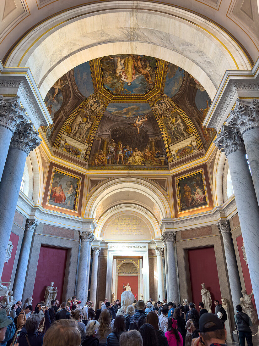 Tourists in the Hall of the Muses in the Pio Clementino Museum, Vatican Museums, Vatican City, Rome, Italy.