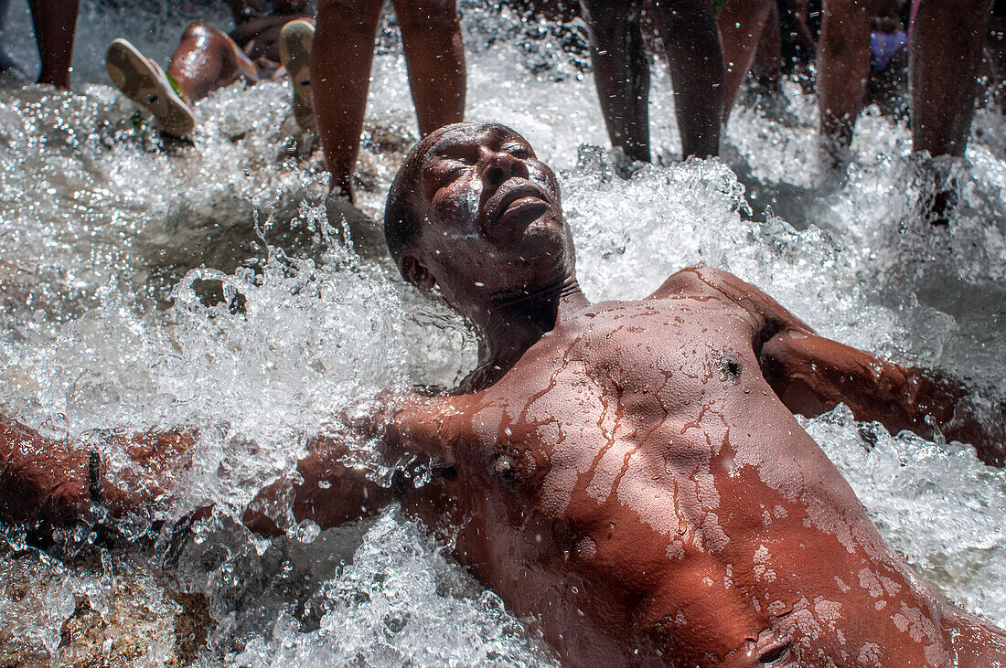 Haiti Voodoo Festival in Saut d'Eau, in Saut d'Eau, Ville Bonheur, Haiti. Thousands of both Vodou and Catholic followers gathered under the Saut d'Eau waterfall in Haiti. The pilgrimage, made by Voodou practitioners and Catholics alike, originated with the sighting of the likeness of the Virgin Mary on a palm leaf close to the falls half a century ago. Catholism and Voodou practices are forever intertwined in its Haitian form. The appearance of a rainbow beneath the falls is said indicate that Danbala - the great lord of the waterfall - and Ayida Wedo - the rainbow - are making love. Fertility