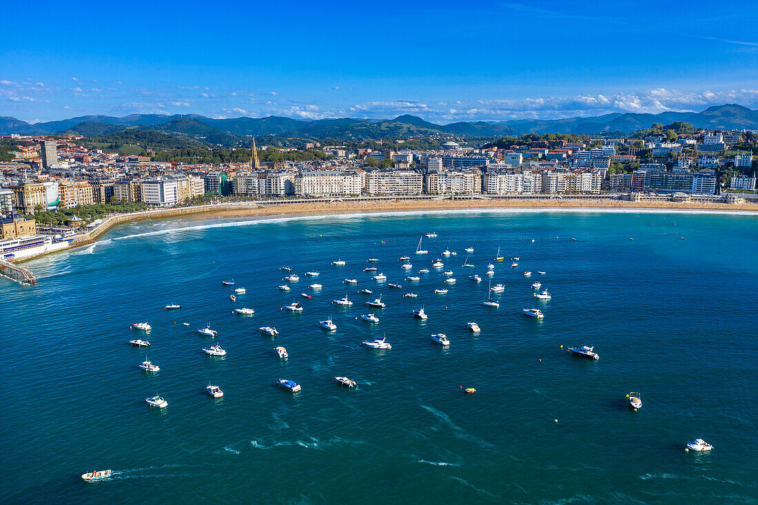 Aerial view of the Playa de la Concha beach and fishing boats and sport fishing boats to recreational boat fishing are moored in the harbor of Donostia San Sebastian.