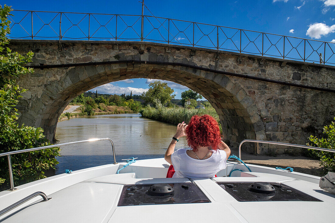 Brücke des Canal du Midi zwischen Homps und Argens Minervois Südfrankreich Südliche Wasserstraße Wasserstraßen Urlauber stehen Schlange für eine Bootsfahrt auf dem Fluss, Frankreich, Europa