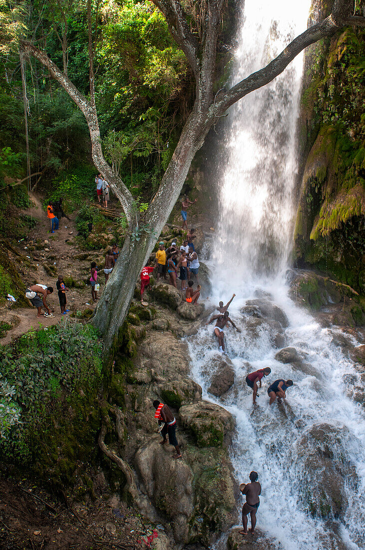 Haiti Voodoo Festival in Saut d'Eau, in Saut d'Eau, Ville Bonheur, Haiti. Tausende von Vodou- und katholischen Anhängern versammelten sich unter dem Wasserfall von Saut d'Eau in Haiti. Die Wallfahrt, die sowohl von Voodou-Anhängern als auch von Katholiken unternommen wird, hat ihren Ursprung in der Sichtung des Bildes der Jungfrau Maria auf einem Palmblatt in der Nähe des Wasserfalls vor einem halben Jahrhundert. Der Katholizismus und die Voodou-Praktiken sind in ihrer haitianischen Form für immer miteinander verwoben. Das Erscheinen eines Regenbogens unter den Wasserfällen soll bedeuten, dass