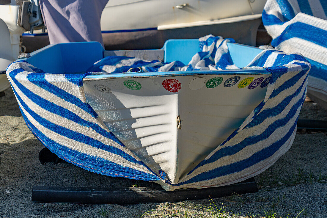 Boats with striped covers on the beach in off peak season at Monterosso al Mare, Cinque Terre, Italy.