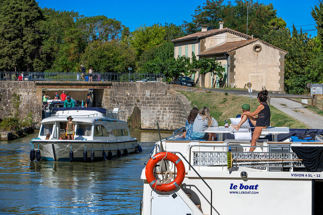 Boat crossing the Écluse de Marseillette look au Ranchin. Canal du Midi at village of Puichéric Carcassone Aude South of France southern waterway waterways holidaymakers queue for a boat trip on the river, France, Europe