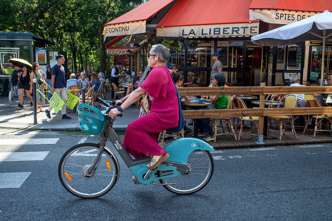 People sitting at La Liberte cafe restaurant on a street avenue in Montparnasse Paris France EU Europe