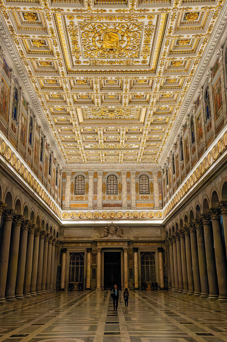 Two people in the central nave the Basilica of St. Paul Outside the Walls, Rome, Italy.