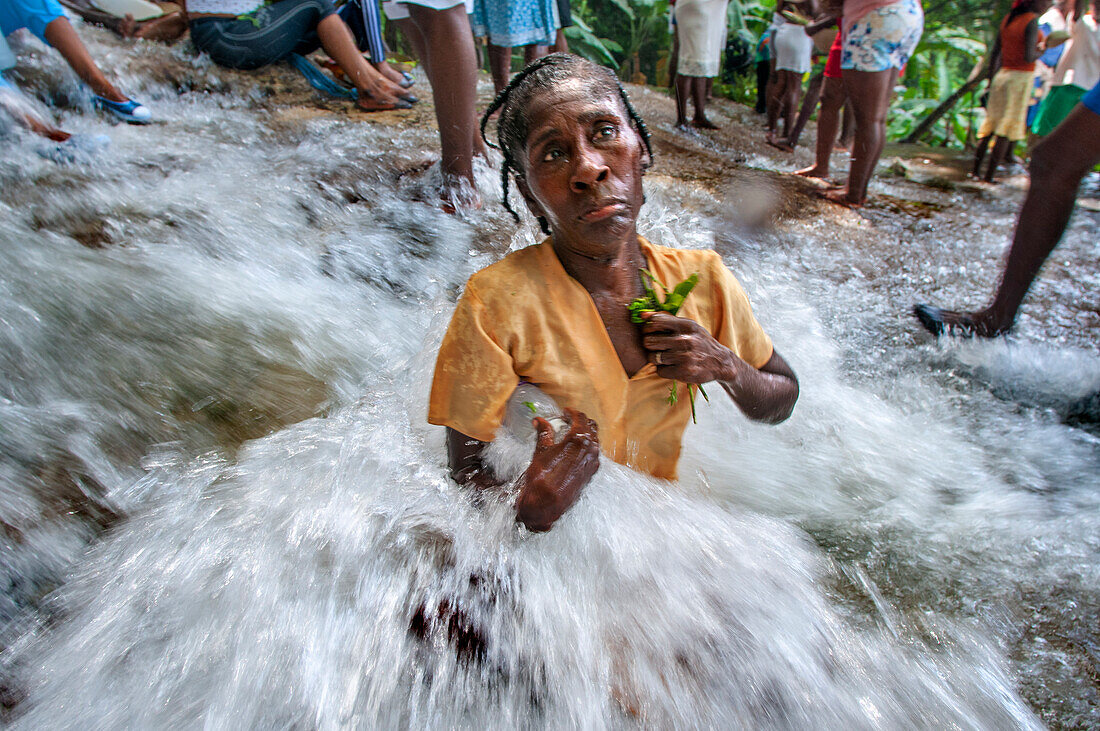 Haiti Voodoo Festival in Saut d'Eau, in Saut d'Eau, Ville Bonheur, Haiti. Thousands of both Vodou and Catholic followers gathered under the Saut d'Eau waterfall in Haiti. The pilgrimage, made by Voodou practitioners and Catholics alike, originated with the sighting of the likeness of the Virgin Mary on a palm leaf close to the falls half a century ago. Catholism and Voodou practices are forever intertwined in its Haitian form. The appearance of a rainbow beneath the falls is said indicate that Danbala - the great lord of the waterfall - and Ayida Wedo - the rainbow - are making love. Fertility