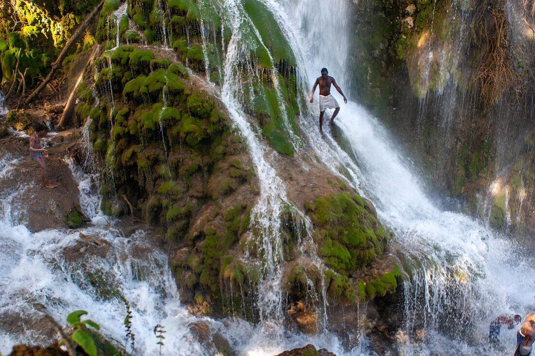 Haiti Voodoo Festival in Saut d'Eau, in Saut d'Eau, Ville Bonheur, Haiti. Tausende von Vodou- und katholischen Anhängern versammelten sich unter dem Wasserfall von Saut d'Eau in Haiti. Die Wallfahrt, die sowohl von Voodou-Anhängern als auch von Katholiken unternommen wird, hat ihren Ursprung in der Sichtung des Bildes der Jungfrau Maria auf einem Palmblatt in der Nähe des Wasserfalls vor einem halben Jahrhundert. Der Katholizismus und die Voodou-Praktiken sind in ihrer haitianischen Form für immer miteinander verwoben. Das Erscheinen eines Regenbogens unter den Wasserfällen soll bedeuten, dass