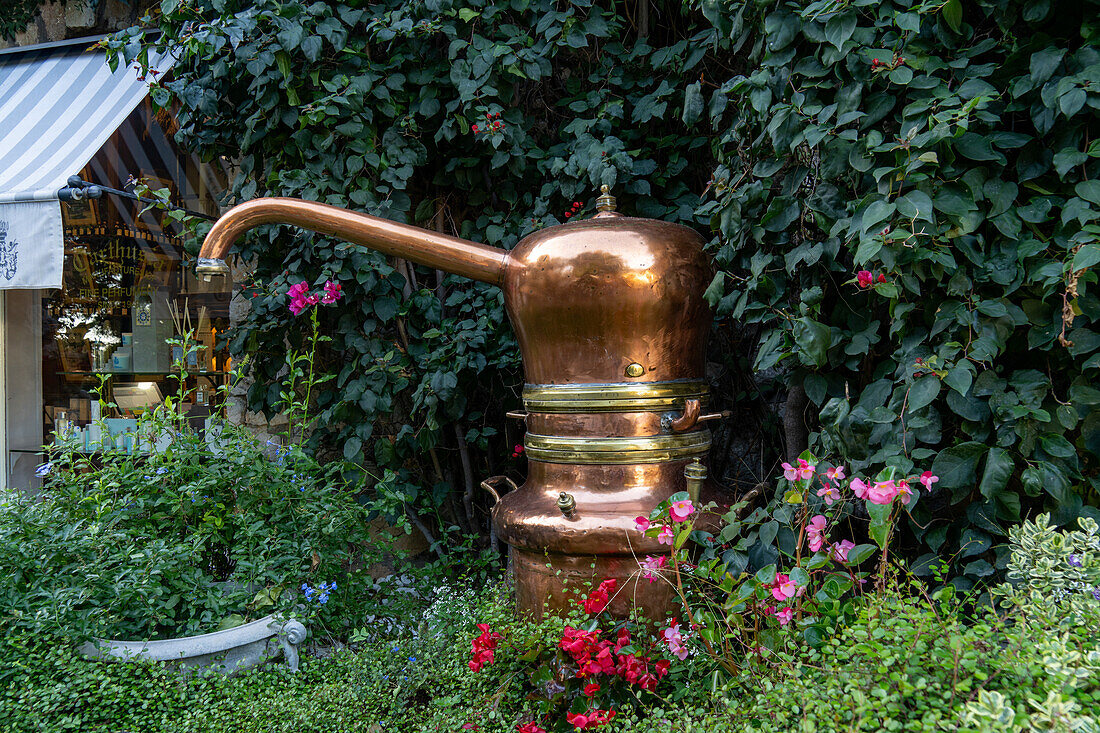 Vintage copper vessels used in the making of perfumes in the garden of a perfumery in Capri, Italy.