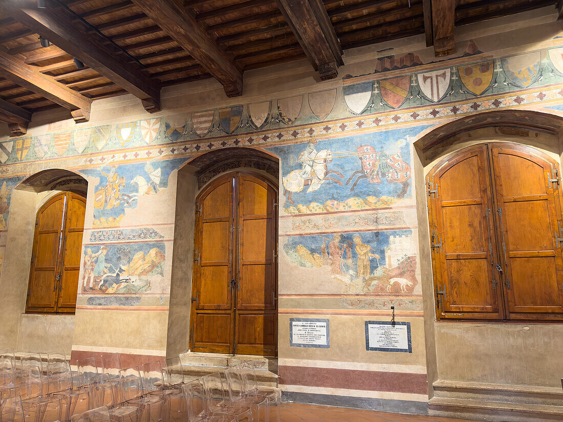 Mittelalterliche Fresken in der Sala di Dante des Palazzo Comunale oder Rathauses aus dem 13. Jahrhundert in San Gimignano, Italien.