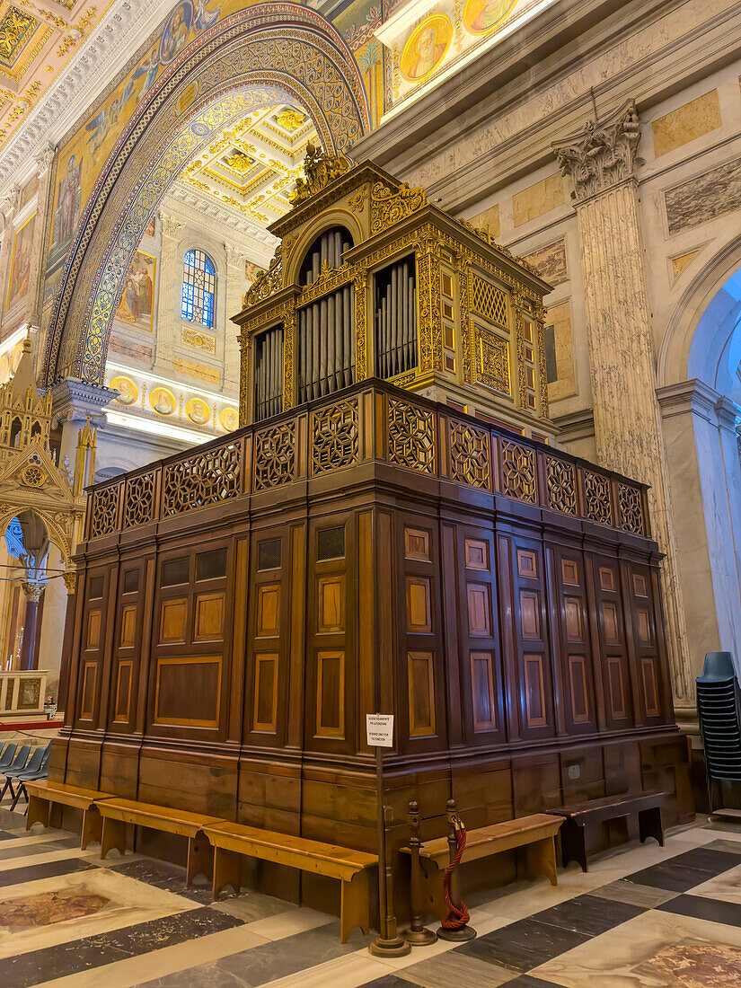 An ornate antique pipe organ in the transept of the Basilica of St. Paul Outside the Walls, Rome, Italy.