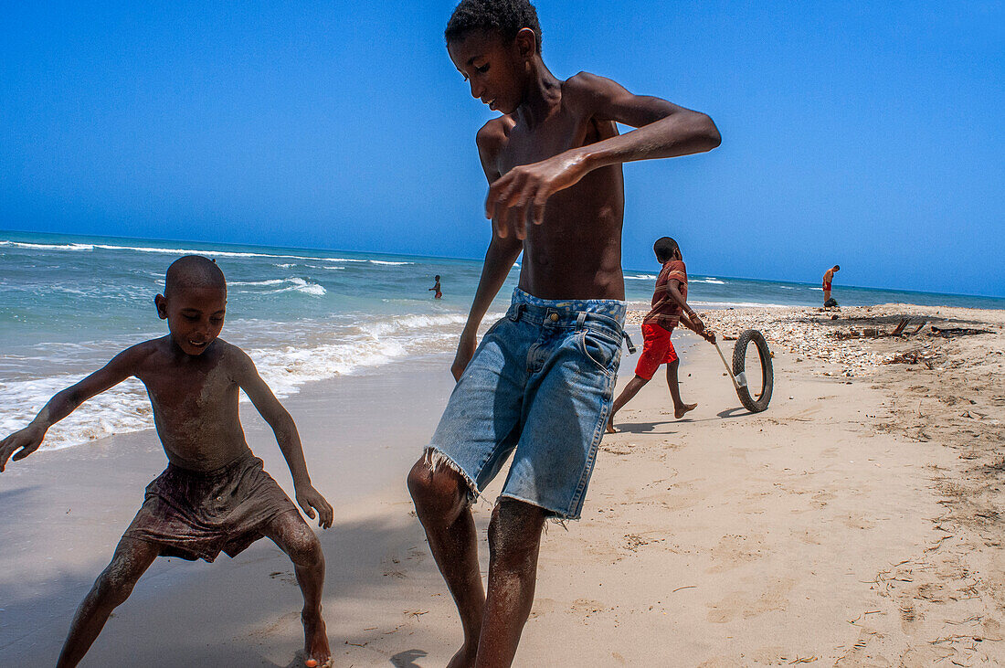 Einheimische Kinder spielen am Strand Plage de Ti Mouillage in Cayes-de-Jacmel, Cayes de Jacmel, Jacmel, Haiti.