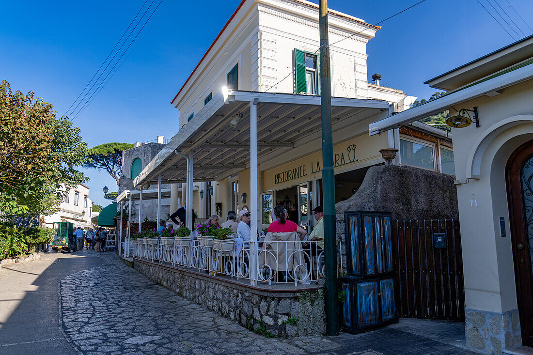 Diners at a restaurant on a street in Anacapri on the island of Capri, Italy.